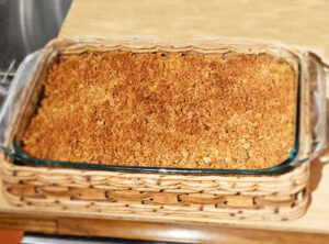 Vegan baked macaroni and cheese in glass casserole dish in wicker basket
